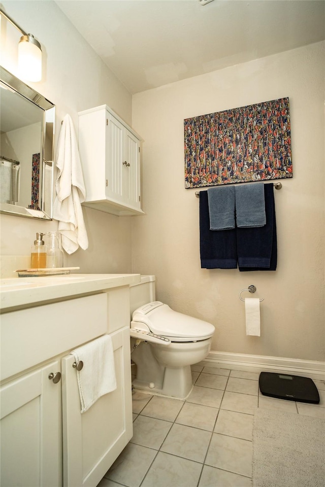 bathroom featuring tile patterned flooring, vanity, and toilet