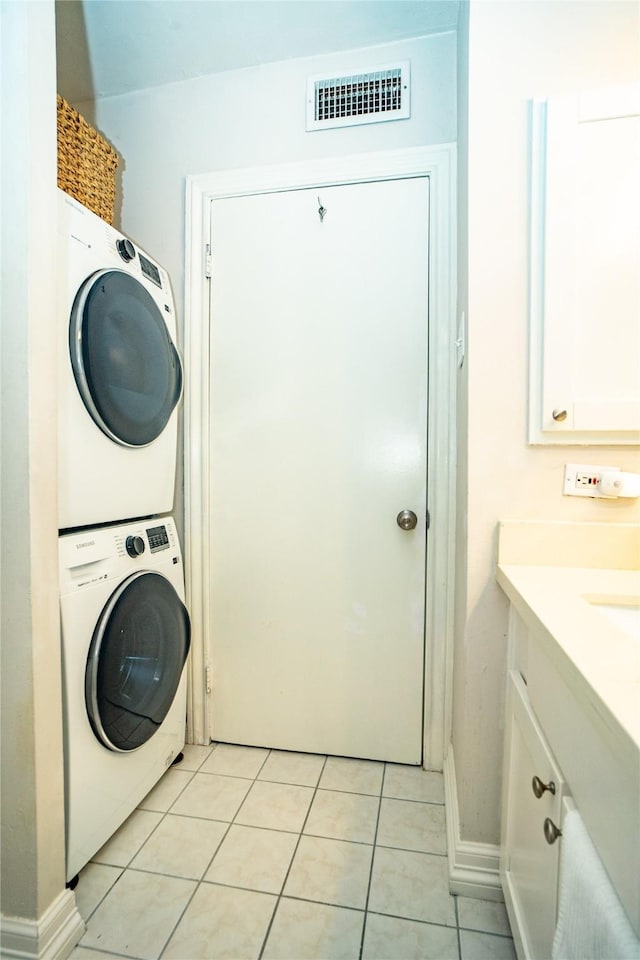 clothes washing area featuring stacked washer / dryer and light tile patterned floors