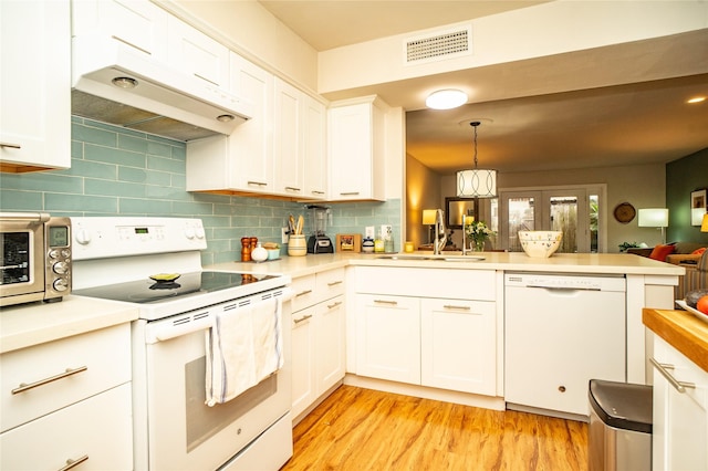 kitchen featuring sink, decorative light fixtures, kitchen peninsula, white appliances, and white cabinets