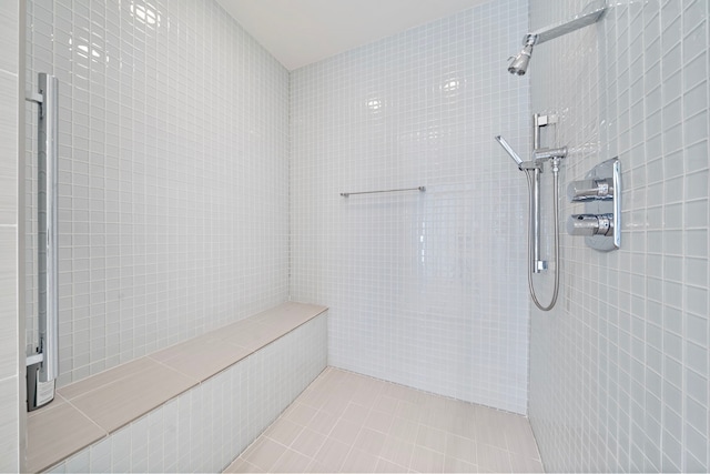 bathroom featuring tile patterned flooring and a tile shower