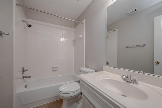 full bathroom with tiled shower / bath combo, vanity, tile patterned floors, and toilet