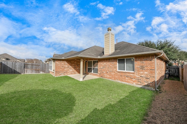 rear view of house featuring a yard and a patio area