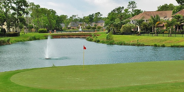 surrounding community featuring a water view and a lawn