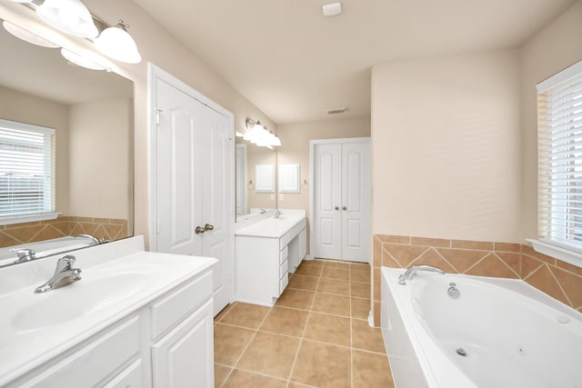 bathroom featuring vanity, a washtub, tile patterned floors, and a healthy amount of sunlight