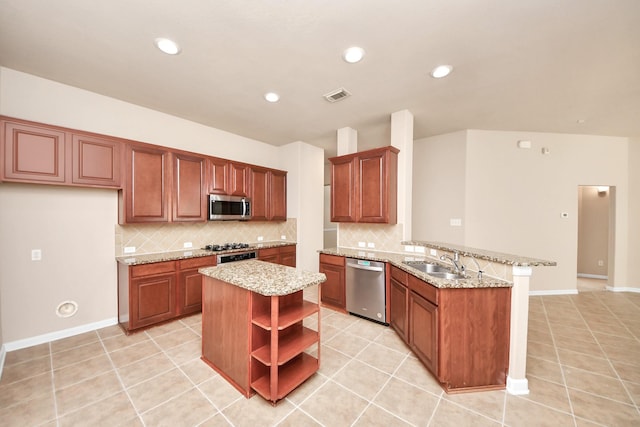 kitchen with light tile patterned flooring, sink, kitchen peninsula, stainless steel appliances, and light stone countertops