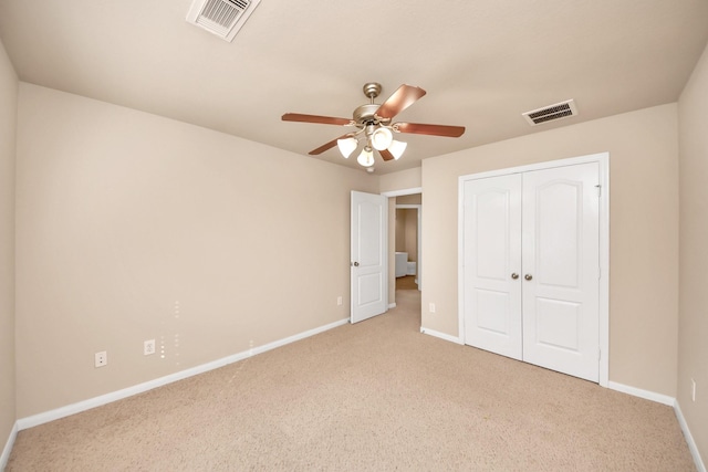 unfurnished bedroom with light colored carpet, a closet, and ceiling fan