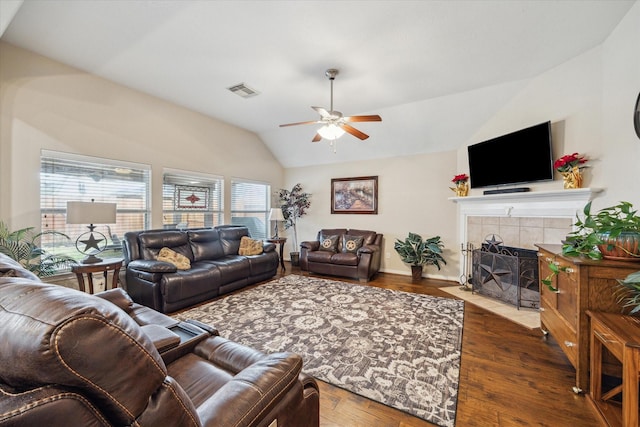 living room featuring lofted ceiling, hardwood / wood-style flooring, a fireplace, and ceiling fan