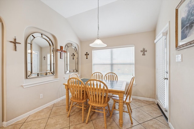 tiled dining room with lofted ceiling