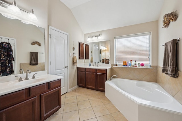 bathroom featuring vanity, vaulted ceiling, tile patterned floors, and a tub