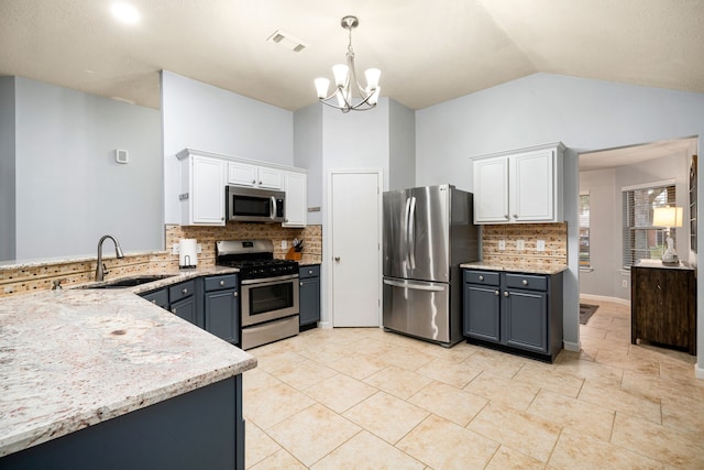 kitchen with stainless steel appliances, white cabinetry, sink, and decorative light fixtures