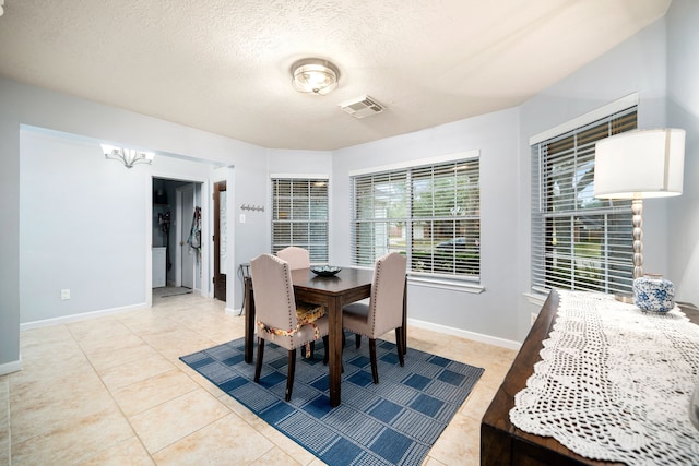 tiled dining space featuring a textured ceiling