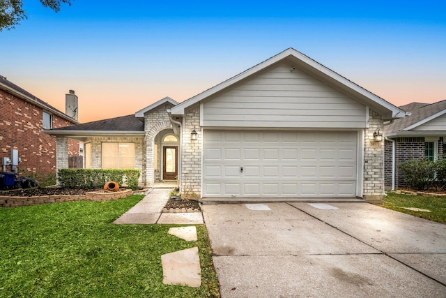 ranch-style home with a garage and a yard