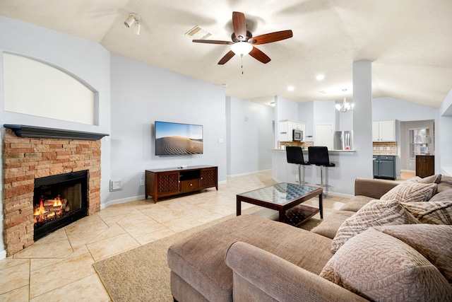 tiled living room with lofted ceiling, ceiling fan with notable chandelier, and a fireplace