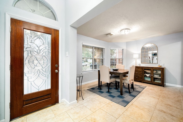 tiled entrance foyer with a textured ceiling