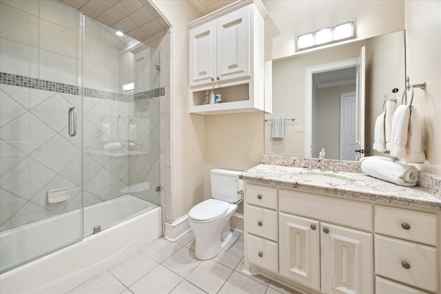 full bathroom with tile patterned floors, toilet, enclosed tub / shower combo, baseboards, and vanity