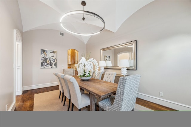 dining area with lofted ceiling, wood finished floors, baseboards, and visible vents