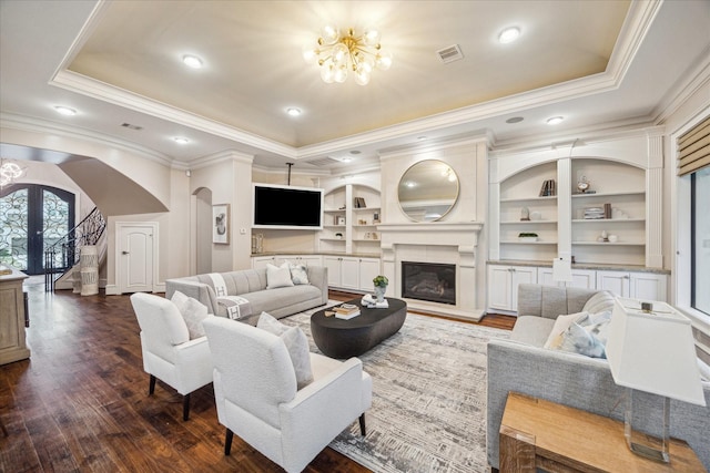 living room featuring a raised ceiling, visible vents, arched walkways, and dark wood-type flooring