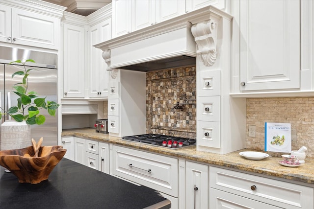 kitchen with decorative backsplash, custom range hood, white cabinets, and stainless steel appliances