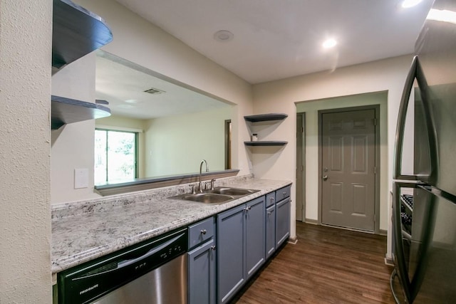 kitchen featuring dishwasher, black fridge, sink, and dark wood-type flooring