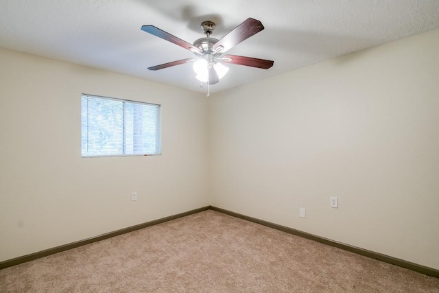 spare room featuring light colored carpet and ceiling fan