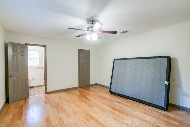 unfurnished bedroom with ceiling fan, ensuite bathroom, and light hardwood / wood-style floors