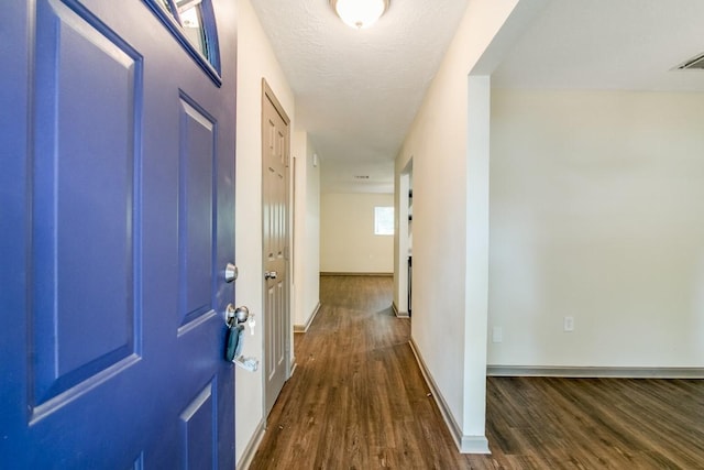 hall featuring dark hardwood / wood-style flooring and a textured ceiling