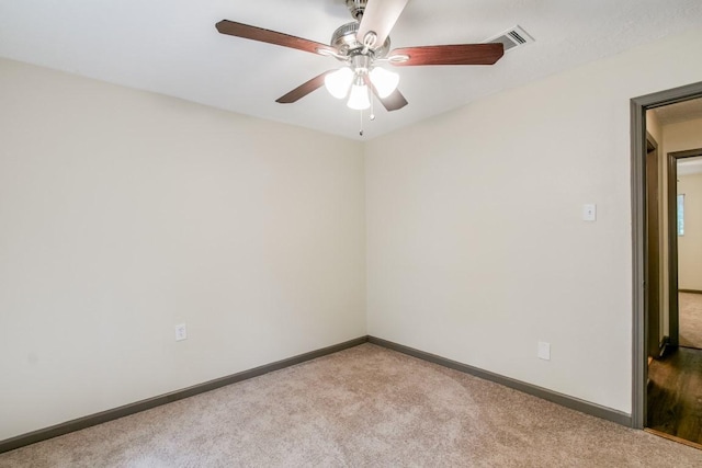 carpeted spare room featuring ceiling fan