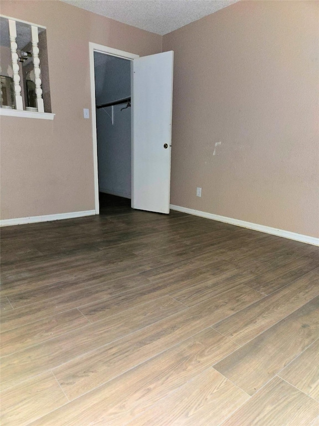 250 El Dorado Unit 296, Webster, TX 77598 - unfurnished bedroom featuring wood finished floors, baseboards, and a closet