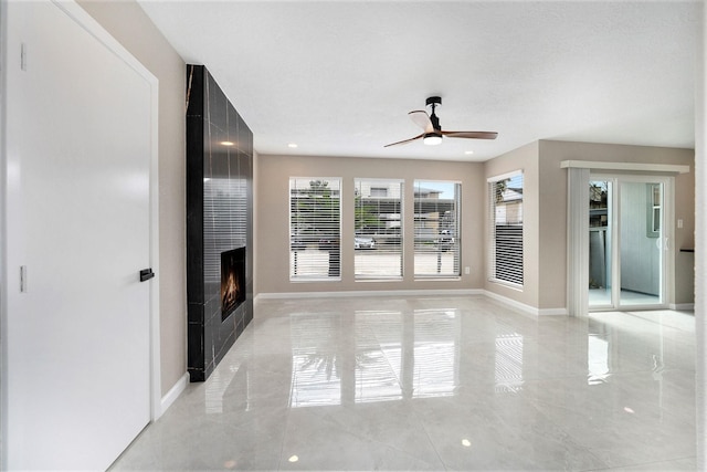 unfurnished living room featuring a fireplace and ceiling fan