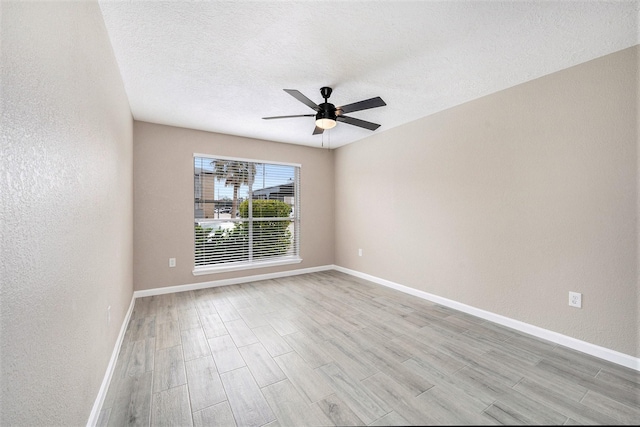 empty room featuring a textured ceiling, light hardwood / wood-style flooring, and ceiling fan