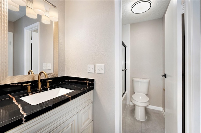 full bathroom featuring enclosed tub / shower combo, vanity, a textured ceiling, tile patterned floors, and toilet