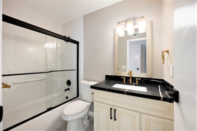 full bathroom featuring bath / shower combo with glass door, vanity, and toilet