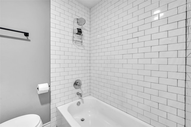 bathroom featuring tiled shower / bath and toilet