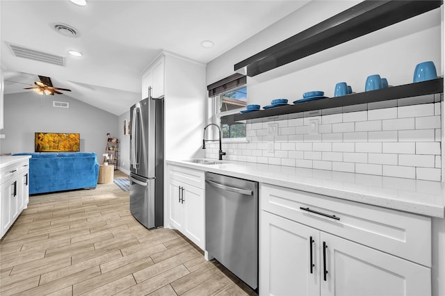 kitchen with light stone countertops, appliances with stainless steel finishes, sink, and white cabinets