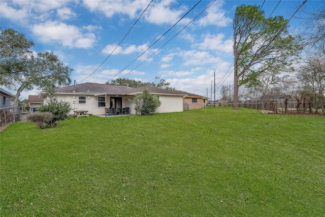 back of house with a patio and a lawn