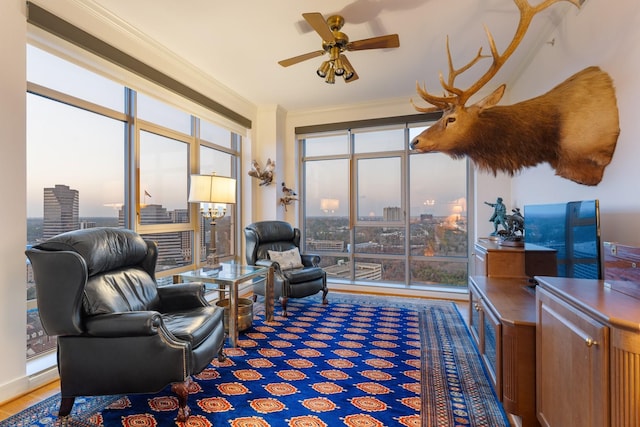 living room featuring hardwood / wood-style flooring, crown molding, and ceiling fan