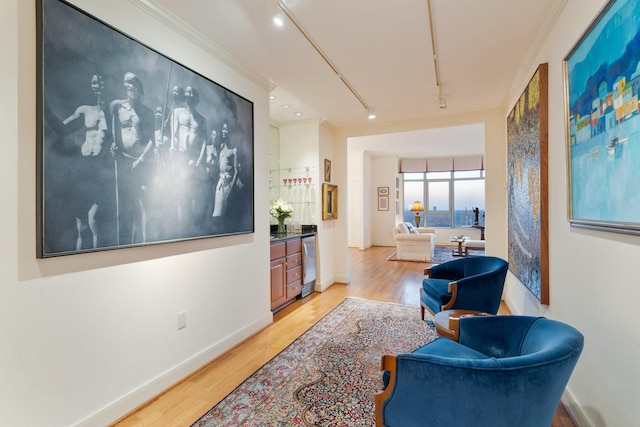 sitting room with ornamental molding, track lighting, and light wood-type flooring