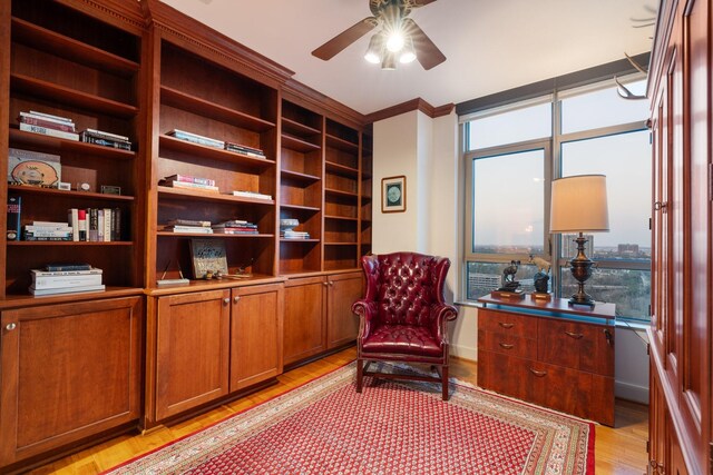 sitting room with ceiling fan, ornamental molding, and light hardwood / wood-style flooring