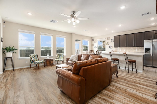 living room featuring light hardwood / wood-style floors and ceiling fan