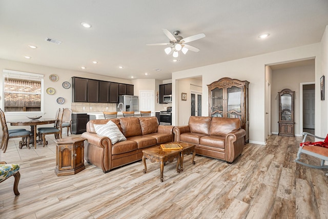 living room featuring ceiling fan and light hardwood / wood-style floors