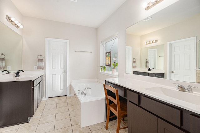 bathroom with tile patterned floors, a tub to relax in, and vanity