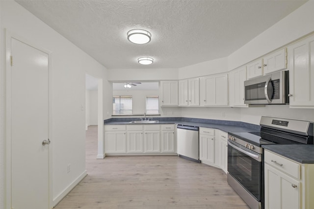 kitchen featuring white cabinetry, sink, light hardwood / wood-style flooring, and appliances with stainless steel finishes