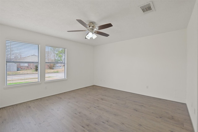 spare room featuring hardwood / wood-style floors, a textured ceiling, and ceiling fan