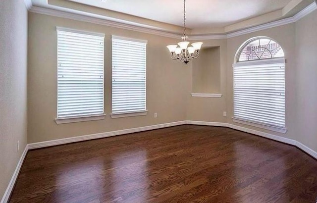 spare room with ornamental molding, dark hardwood / wood-style flooring, and a chandelier