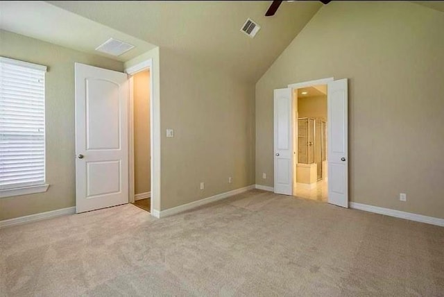 unfurnished bedroom with ceiling fan, high vaulted ceiling, and light carpet