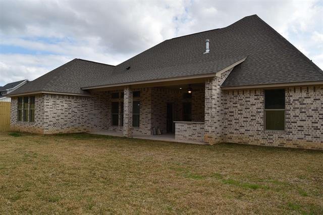 back of property with a yard and a patio area