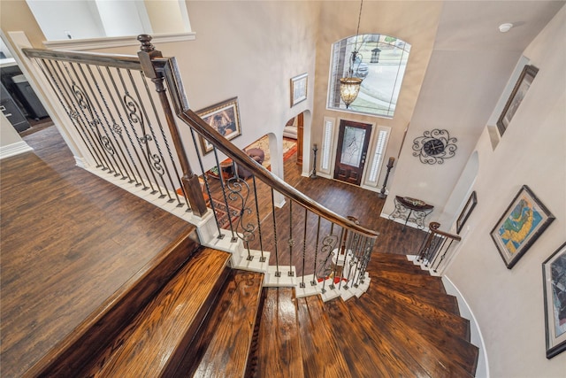 entrance foyer featuring a towering ceiling and dark hardwood / wood-style flooring