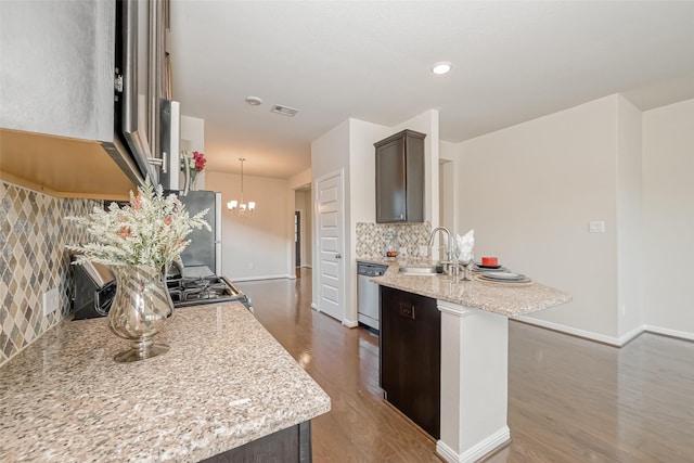 kitchen featuring light stone counters, appliances with stainless steel finishes, sink, and dark brown cabinets