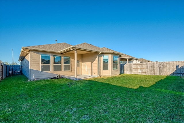 rear view of house with a yard and a patio