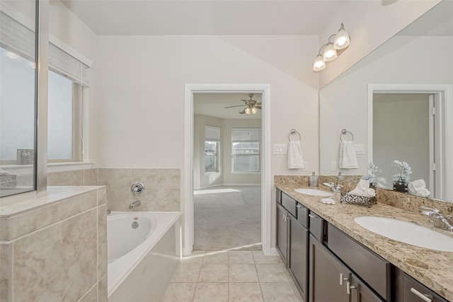 bathroom with ceiling fan, a tub to relax in, vanity, and tile patterned flooring